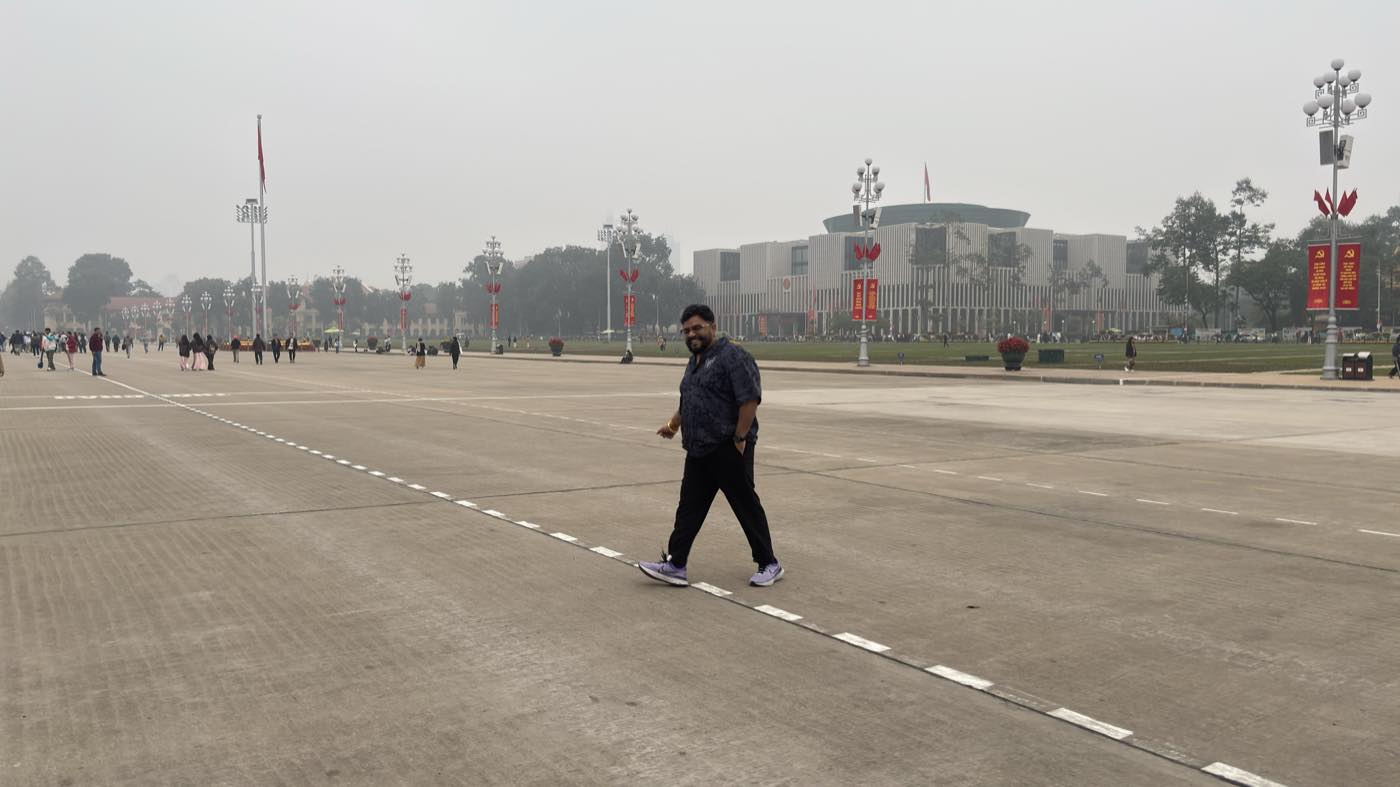 Niraj Choksi walking across a large public square while travelling