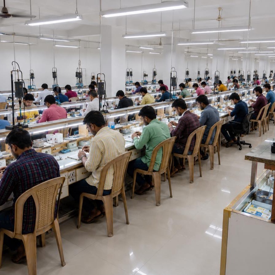 Rows of jewellers at work on a fine-jewellery manufacturing floor.